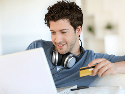 Man looking at laptop and using credit card